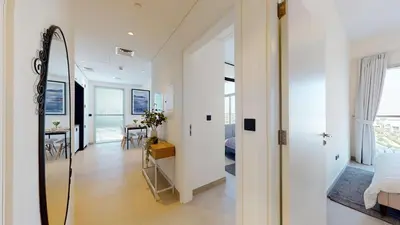 a room with a mirror and a bedroom with a bed at Tranquil Oasis 2BR at Collective Dubai Hills in Dubai