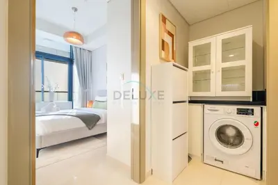 a bedroom with a bed and a washing machine at Close to Dubai Water Canal 1BR with Balcony, Aykon City 2 Tower C, Business Bay by Deluxe Holiday Homes in Dubai