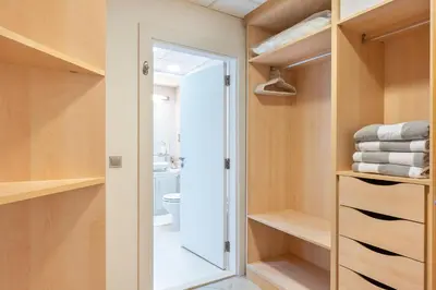 a walk in closet with wooden shelves and a glass door at BURJ views Private Beach 2 Bedroom Apartment with panoramic Sea View and Pool Palm Jumeirah in Dubai
