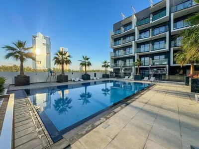 a swimming pool in front of a building at GuestReady - Modern living in JVC in Dubai