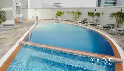a large swimming pool with chairs in a building at ZenStay - Cozy Studio with City Views in Dubai