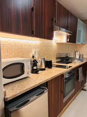 a kitchen with a microwave on a counter at ZenStay - Cozy Studio with City Views in Dubai