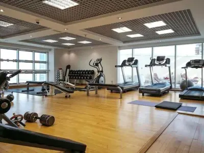 a gym with several treadmills and machines in a room at ZenStay - Cozy Studio with City Views in Dubai