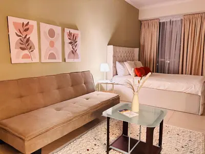 a living room with a couch and a bed at ZenStay - Cozy Studio with City Views in Dubai