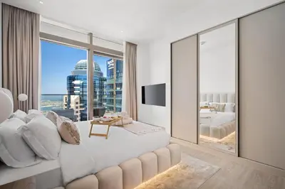 a bedroom with a large bed and a large window at Marina Gate Luxury Full Marina & Sunset Sea Views in Dubai