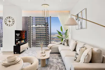 a living room with white furniture and a large window at Marina Gate Luxury Full Marina & Sunset Sea Views in Dubai