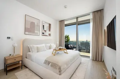 a white bedroom with a bed and a large window at Marina Gate Luxury Full Marina & Sunset Sea Views in Dubai