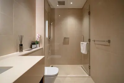 a bathroom with a shower with a toilet and a sink at Marina Gate Luxury Full Marina & Sunset Sea Views in Dubai