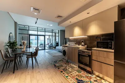 a kitchen with a table and a dining room at HAVN - Modern Studio in JVC with Huge Layout in Dubai
