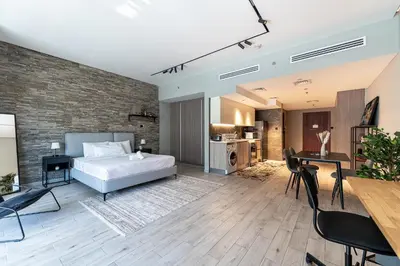 a bedroom with a bed and a table and chairs at HAVN - Modern Studio in JVC with Huge Layout in Dubai