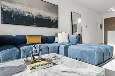 a living room with a blue couch and a table at Luxury 1BR in Downtown l Close to Dubai Mall in Dubai