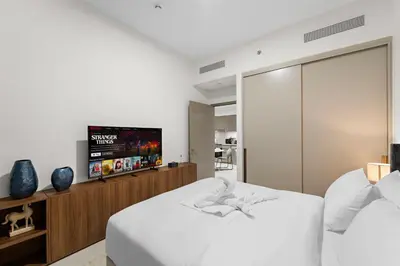 a bedroom with two beds and a flat screen tv at Luxury 1BR in Downtown l Close to Dubai Mall in Dubai