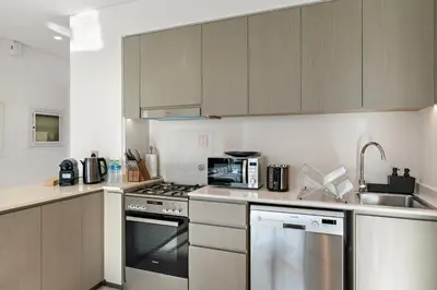 a kitchen with stainless steel appliances and wooden cabinets at Luxury 1BR in Downtown l Close to Dubai Mall in Dubai