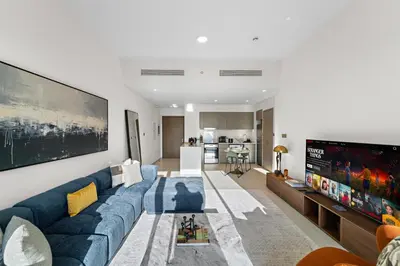 a living room with a blue couch and a tv at Luxury 1BR in Downtown l Close to Dubai Mall in Dubai