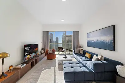 a living room with a blue couch and a tv at Luxury 1BR in Downtown l Close to Dubai Mall in Dubai
