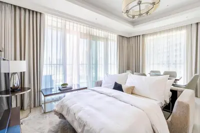 a bedroom with a large white bed and a desk at The ME Apartment in Dubai