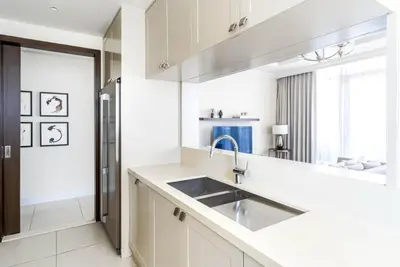 a kitchen with white cabinets and a sink at The ME Apartment in Dubai