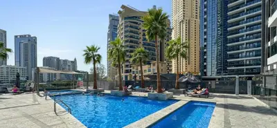 a large swimming pool in a city with tall buildings at The ME Apartment in Dubai