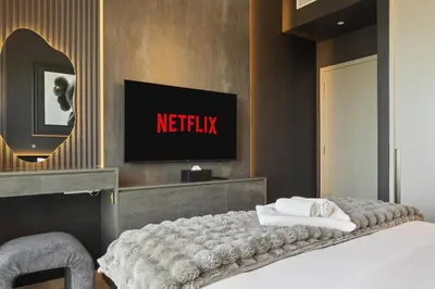 a bedroom with a bed with a tv on the wall at Luxury 1-Bedroom, High-Floor, Skyline Views in Dubai