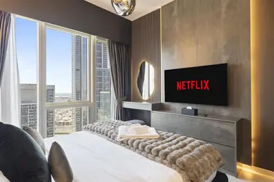 a hotel room with a tv and a bed and a window at Luxury 1-Bedroom, High-Floor, Skyline Views in Dubai