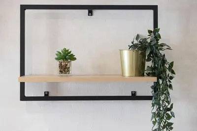 a mirror with two potted plants on a wall at Lake View Studio near Marina with Pool, Sauna and Gym in Dubai