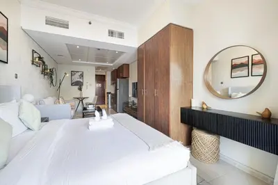 a bedroom with a large white bed and a mirror at Lake View Studio near Marina with Pool, Sauna and Gym in Dubai