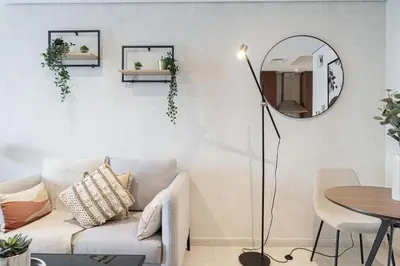 a living room with a couch and a mirror at Lake View Studio near Marina with Pool, Sauna and Gym in Dubai