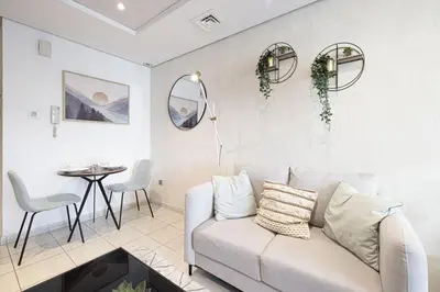 a living room with a couch and a table at Lake View Studio near Marina with Pool, Balcony and Gym in Dubai