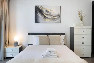 a bedroom with a large white bed with a black headboard at Waterfront Studio, perfectly located in Dubai Marina in Dubai