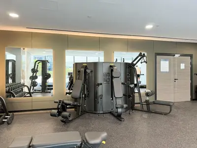 a gym with several tread machines and mirrors at Waterfront Studio, perfectly located in Dubai Marina in Dubai