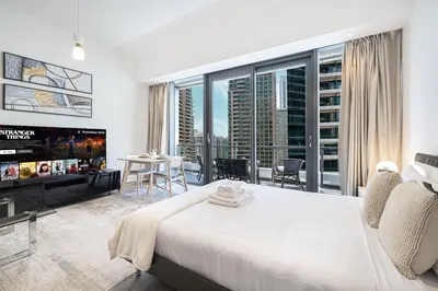 a bedroom with a large white bed and a large window at Waterfront Studio, perfectly located in Dubai Marina in Dubai