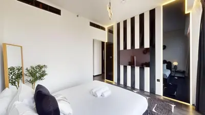 a bedroom with a white bed and a mirror at O Ten - Classy One Bedroom in Al Jaddaf in Dubai