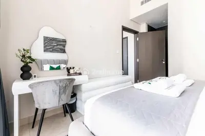 a bedroom with a white bed and a desk at Luxurious Furnishing Direct Access to Dubai Mall in Dubai