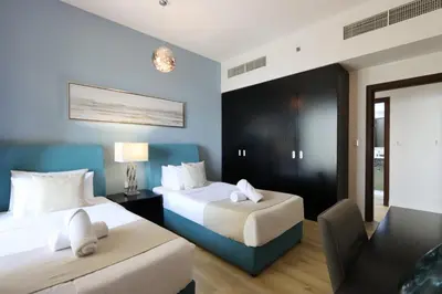 a hotel room with two beds and a chair at Livbnb - Spacious 2B in Shams with Marina View Walk to Beach in Dubai