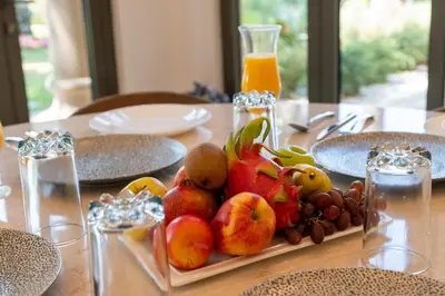 a table with a plate of fruit on a table at Samaya Holiday Homes - Luxury Villa Pool - Beach Access & Fishing Zone in Dubai