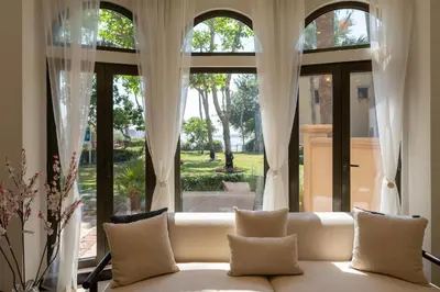 a couch sitting in front of a large window at Samaya Holiday Homes - Luxury Villa Pool - Beach Access & Fishing Zone in Dubai