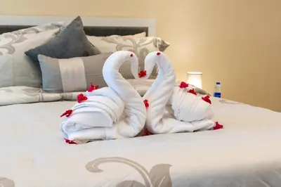 two swans made out of towels on a bed at Samaya Holiday Homes - Luxury Villa Pool - Beach Access & Fishing Zone in Dubai