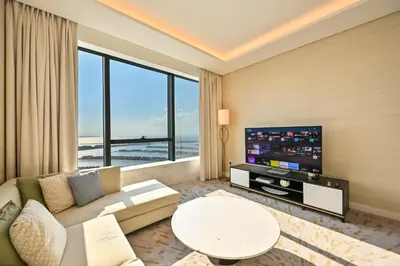 a living room with a couch and a tv at Stylish 1-BR Retreat with Sweeping Views in Palm Tower in Dubai