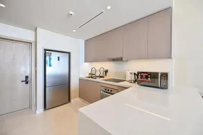a kitchen with a white counter top and a refrigerator at Stylish 1-BR Retreat with Sweeping Views in Palm Tower in Dubai