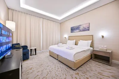 a hotel room with a bed and a flat screen tv at Stylish 1-BR Retreat with Sweeping Views in Palm Tower in Dubai