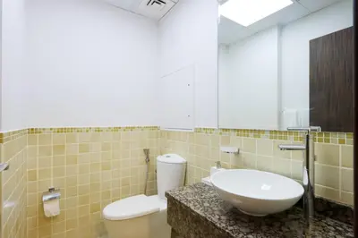 a bathroom with a sink and a toilet and a mirror at Livbnb- Coastal 2B with Marina View Walk to Beach in Dubai
