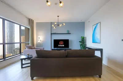 a living room with a couch and a tv at Livbnb- Coastal 2B with Marina View Walk to Beach in Dubai