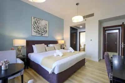 a large bedroom with a large bed and a table at Livbnb - High Floor 2B with Marina View Walk to Beach in Dubai