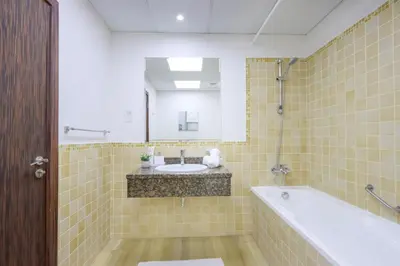 a bathroom with a sink and a tub and a mirror at Livbnb - High Floor 2B with Marina View Walk to Beach in Dubai