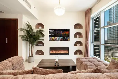 a living room with a couch and a fireplace at Splendid 2BR Burj Khalifa & Fountain view in Dubai
