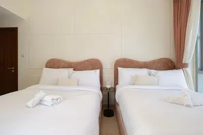 two beds in a room with white sheets at Splendid 2BR Burj Khalifa & Fountain view in Dubai