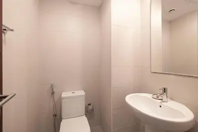 a white bathroom with a toilet and a sink at Splendid 2BR Burj Khalifa & Fountain view in Dubai