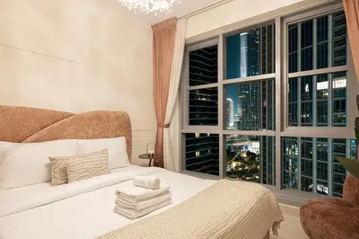 a bedroom with a bed and a large window at Splendid 2BR Burj Khalifa & Fountain view in Dubai
