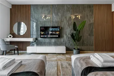 a bedroom with two beds and a tv on the wall at JBR Coastal Escape - Amazing Sea Views, Pool & State-of-the-Art Gym in Dubai