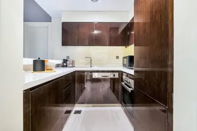 a kitchen with wooden cabinets and white counter tops at GuestReady - Luxe Comfort in Bussiness Bay in Dubai